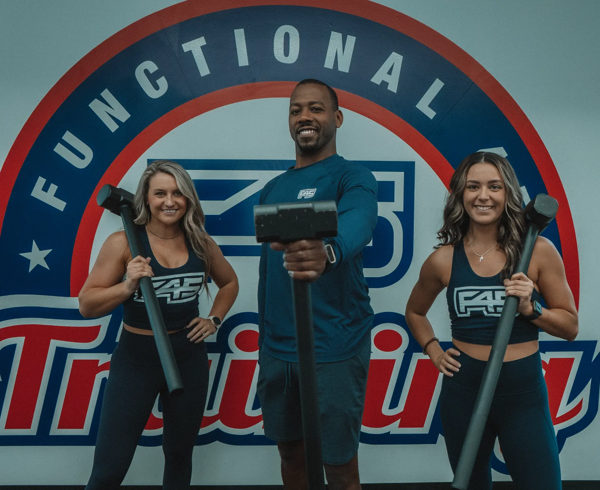 F45 trainers with equipment in front of the functional training wall.